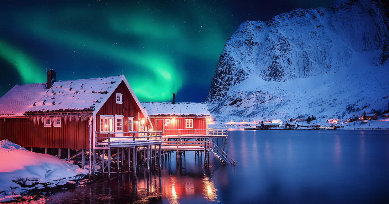 Scenic photo of winter fishing village with northern lights. stunning natural background. Picturesque Scenery of Reinefjord one most popular place of Lofoten Islands. Norway